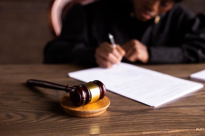 Imagen que representa un juez firmando un documento legal en un proceso judicial, destacando la importancia de cada etapa en el sistema legal.